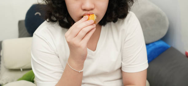istock Young asian girl eating snack 1695467040