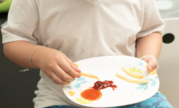 kid eat french fries in room - teen obesity imagens e fotografias de stock