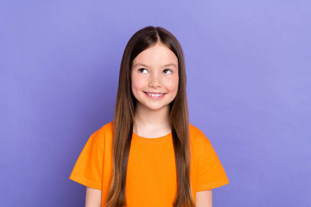 istock Portrait of cute schoolgirl student looking empty space imagination creative ideas how spent summer isolated on purple color background 1695468151