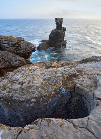 Waves hit a rocky sea stack in Peniche, Portugal