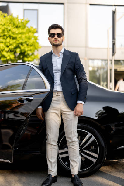 istock Businessman standing near luxury car 1695511756