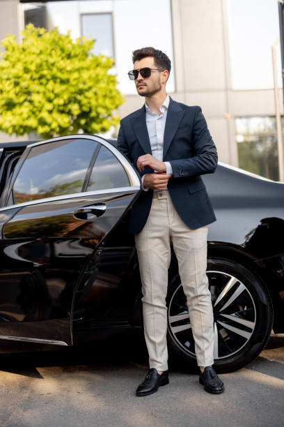 istock Businessman standing near luxury car 1695512262