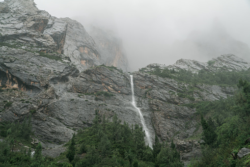 Landscape of a mountain and fog rolling down the slope. Concept of autumn cold