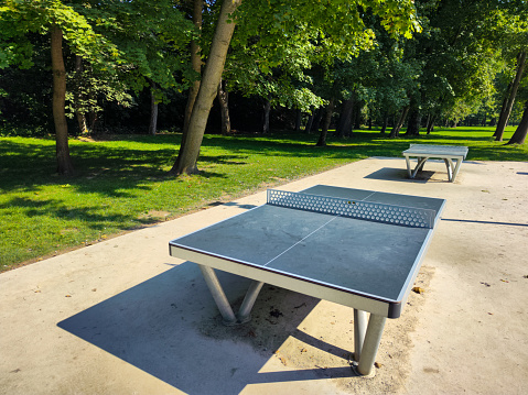 A tennis table in the city park on a sunny summer day available for free play to everyone.