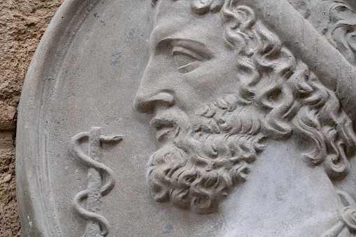 Asclepius (Aesculapius) god of treatment, the son of Apollo and Koronidy. Close up an ancient statue.