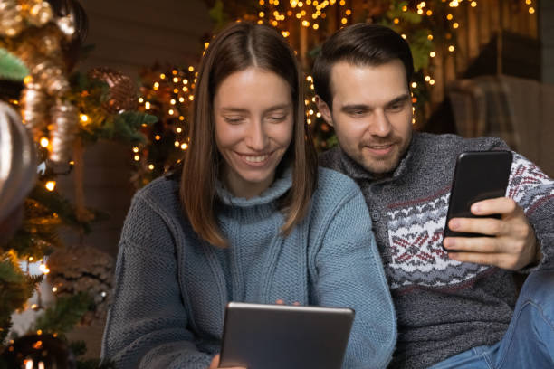 istock Happy young couple using different gadgets at home. 1695600834