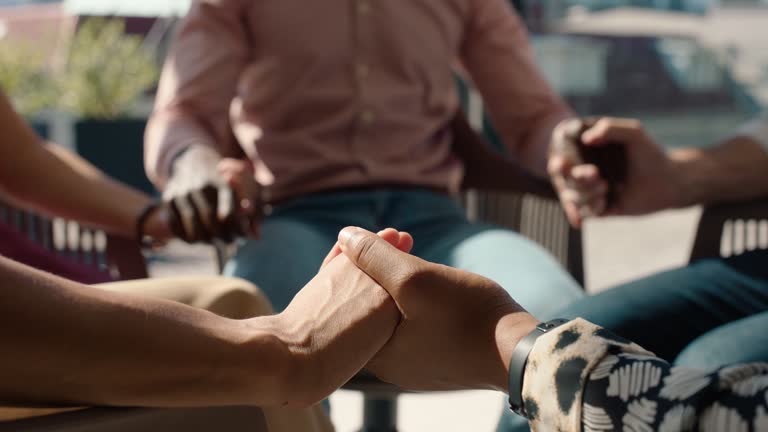 Hand holding, support and a group praying together for counseling, religion and spiritual healing. People, friends or community with gratitude, therapy and kindness in circle for prayer and meeting