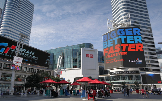 Toronto, Canada - August 22, 2023: Yonge-Dundas Square is a popular gathering point downtown with views of projected images. The Toronto Eaton Centre, a large shopping mall, stands across at 220 Yonge Street.