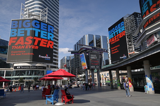 Toronto, Canada - August 22, 2023: Looking west from Yonge-Dundas Square to the advertisements on giant projection screens. Summer morning in the downtown district.