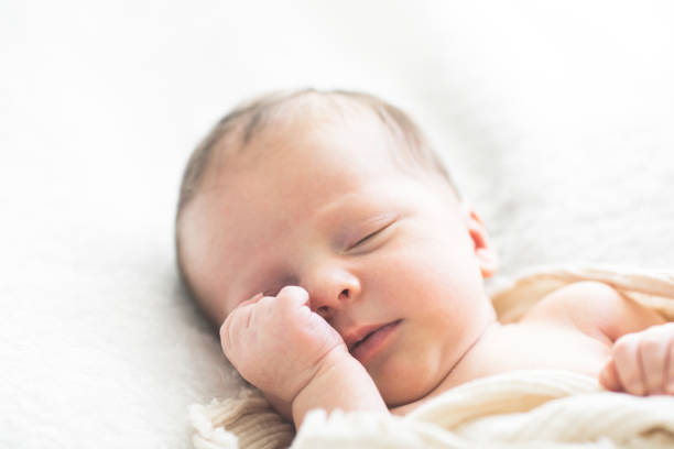 istock Cute baby sleeping 5 days old on light blanket. Banner design with space for text 1695669176