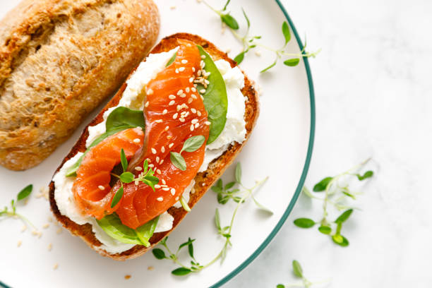 istock Salmon salted sandwich with spinach and cream cheese, top down view 1695688072