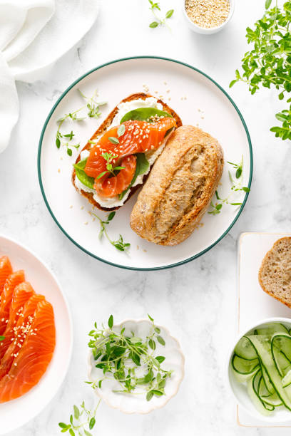 istock Salmon salted sandwich with spinach and cream cheese, top down view 1695688104