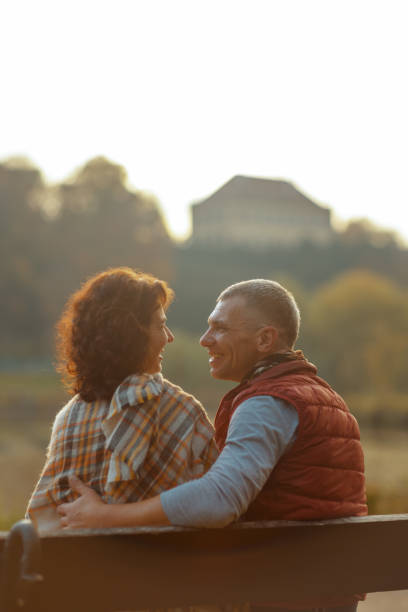 istock boyfriend and girlfriend in park hugging while sitting on bench 1695738479