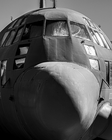 Front view of U.S. Air Force military AC-130 Hercules nose and pilot windows in monochrome