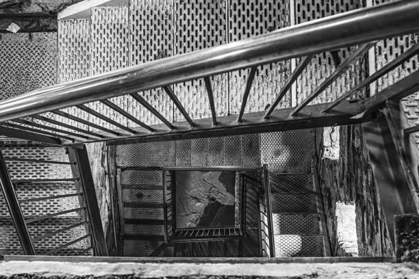istock Looking down metal staircase in tall tower and banister back and forth to bottom 1695752340
