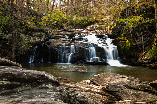 Beautiful waterfall cascading in scenic autumn or Fall setting with large rocks and ruins in Georgia