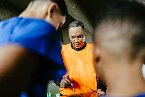 Soccer coach talking with players on the soccer field