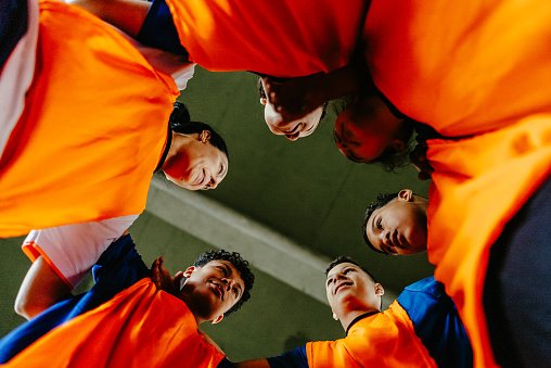 Low angle view of a soccer team huddling on the soccer field
