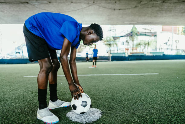 Soccer player putting the ball on soccer field