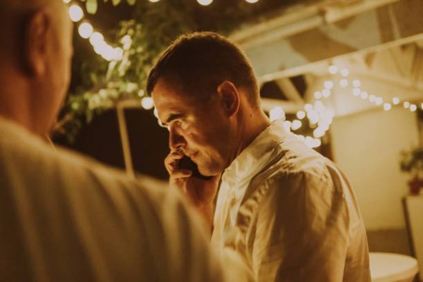 istock Man talking on the phone at party 1695839074