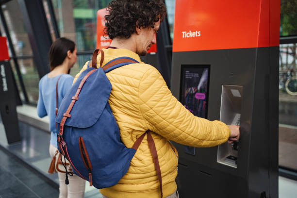 istock Men buying train ticket at the train station 1695858091