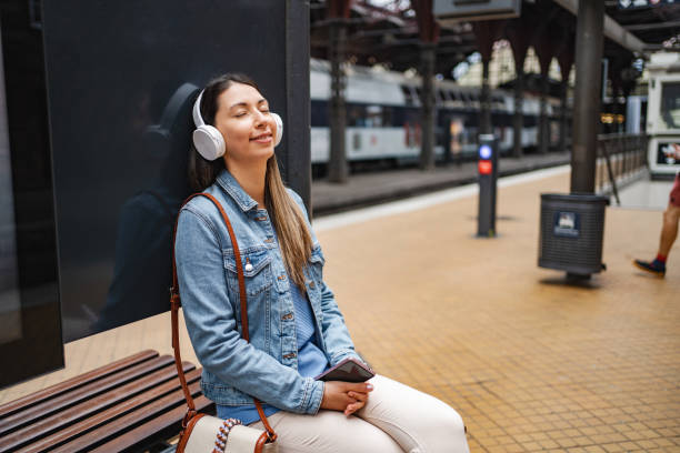 istock Young woman using her mobile phone at the train station 1695859147