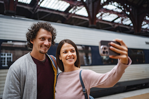 Couple taking selfies at the train station