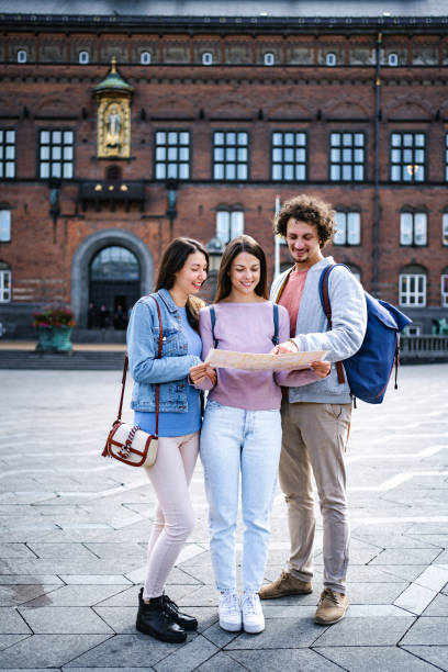 istock Three happy tourists looking at a map while exploring the city of Copenhagen 1695861437