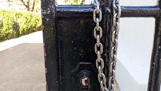 Low angle view of a padlock on an old metal gate.