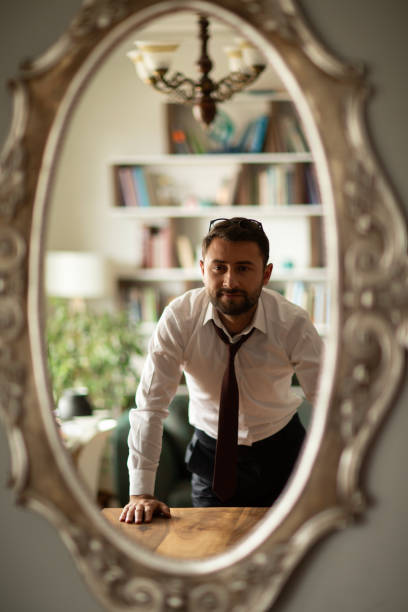istock Businessman getting dressed in front of the mirror 1695882700