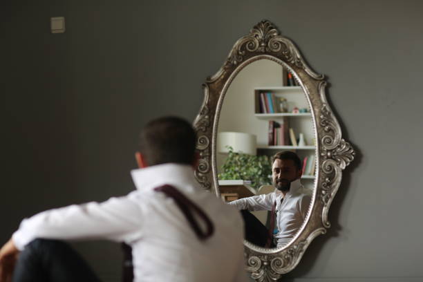 istock Businessman getting dressed in front of the mirror 1695882988