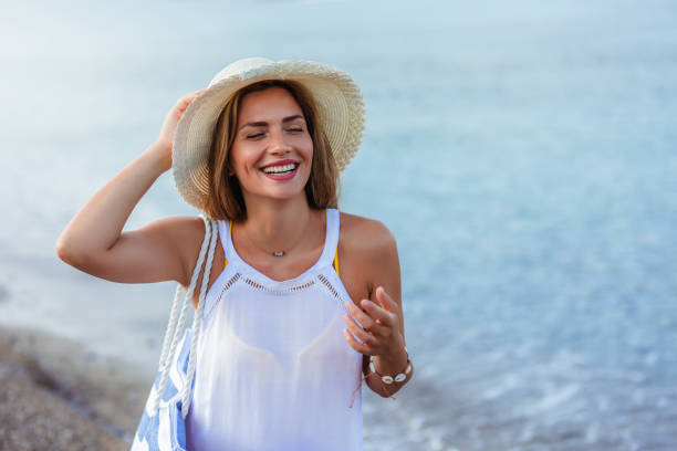 istock Happy young beautiful woman walking alone on the beach 1695883120
