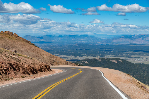 Curves and big drop-offs of the Steep Pikes Peak highway to the summit of America's Mountain (elevation 14115 feet) in the Rocky Mountains in central Colorado in western USA of North America. Nearby cities are Colorado Springs, Denver and Pueblo, Colorado.