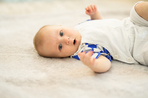 6 month old baby crawling on the floor in the living room of the house