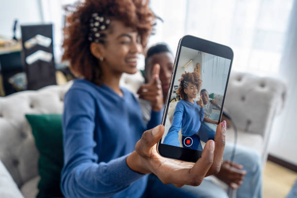 istock Mother and son dancing and singing with cell phone at home. 1695964082