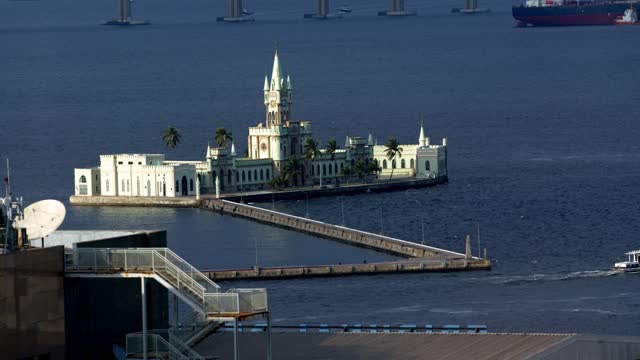 Historic Ilha Fiscal island customs building, static shot of slow boat leaving Guanabara Bay Rio de Janeiro