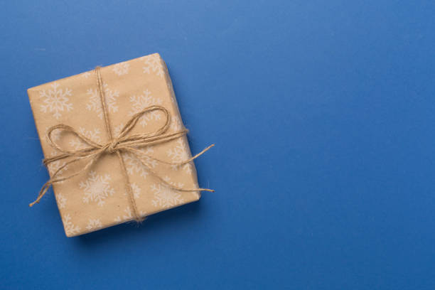 istock Craft christmas gift boxes on color background, top view 1696024636