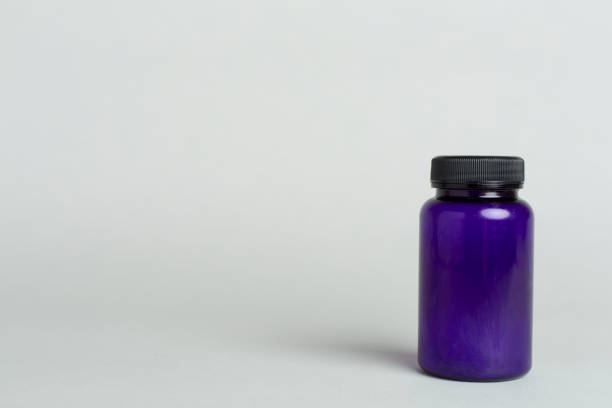 Blank plastic pill bottle on a light blue background