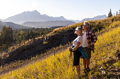 Mature hiking couple pause to enjoy mountain view