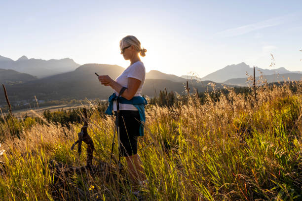 istock Mature female hiker pauses on mountain meadow 1696043909
