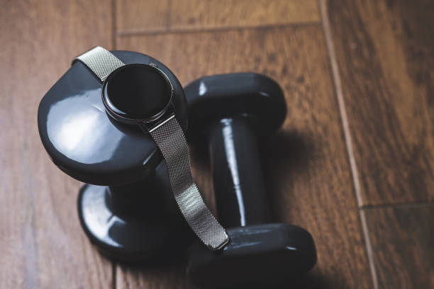 istock Connected Fitness: Smartwatch and Dumbbells on Wooden Floor. 1696123866