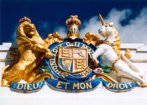 Canberra, ACT, Australia: British Royal insignia at the Old Parliament House, coat of arms of the United Kingdom of Great Britain and Northern Ireland - In the first and fourth fields of the coat of arms there is an image of the coat of arms of England. The second field contains the coat of arms of Scotland, while the third field depicts the coat of arms of Ireland. The coat of arms is crowned with a helmet, surmounted by a crown. The coat of arms is carried by two shield holders: a crowned lion, representing England, and a unicorn, representing Scotland. The unicorn is chained. \