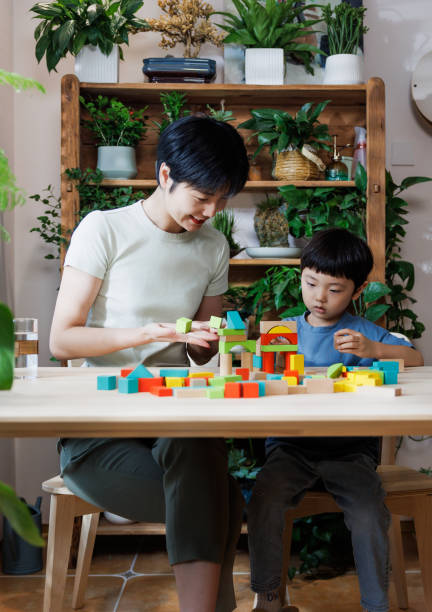 istock asian mom is playing building blocks with her son at home 1696163265