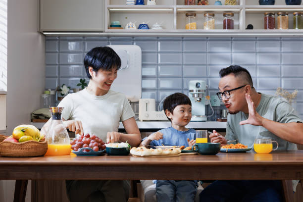 istock Parents and young son dining together in dining room. 1696163418