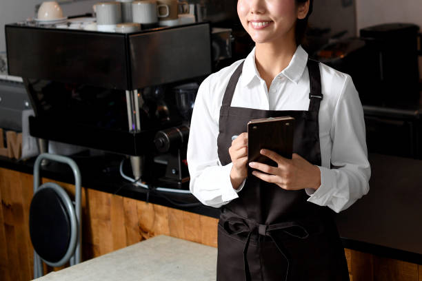 smiling young asian woman in front of the kitchen counter at a restaurant - soda jerk imagens e fotografias de stock