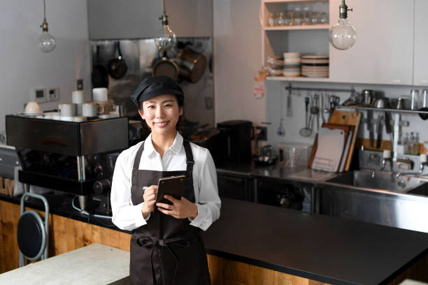 smiling young asian woman in front of the kitchen counter at a restaurant - soda jerk imagens e fotografias de stock