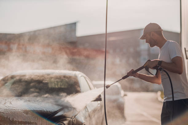 istock Worker washing car at self-service car wash 1696213616
