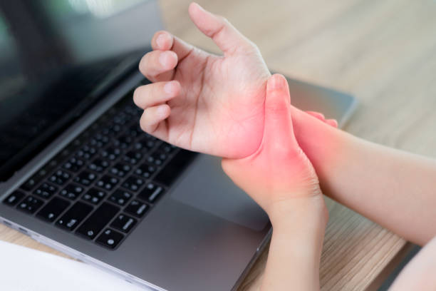 istock Young asian woman feeling hurts her wrists after working on computer laptop for a long time. Concept woman suffering from hurts in wrists. Office syndrome and work from home, health insurance concept 1696377302
