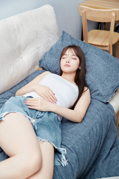 istock An Asian woman sleeping on the sofa 1696381116