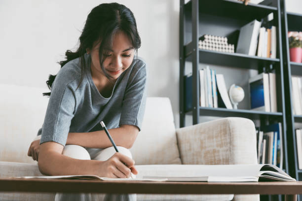 istock Teenager doing homework in living room. 1696409491